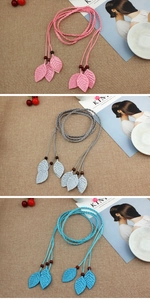Detail of woven waist ropes with glitter leaf charms and wood beads in pink grey and blue