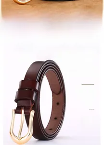 Close-up of a slim dark reddish-brown leather belt with an elegant gold horseshoe buckle