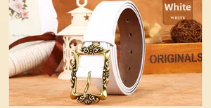Détail d'une ceinture en cuir blanc avec boucle en bronze antique de style vintage