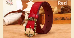Détail d'une ceinture en cuir rouge gaufré avec une boucle dorée sculptée vintage