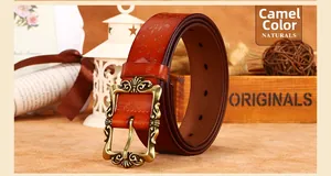 Détail d'une ceinture vintage en cuir camel avec motifs floraux et boucle en bronze sculpté