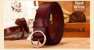 Close-up of red wine leather belt with round golden buckle and vintage accessories