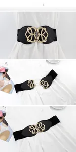 Detail of black wide elastic belt for dresses with gold heart-shaped buckle and leather trim