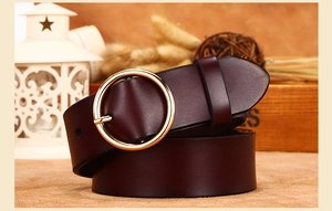 Close-up of a deep burgundy leather belt with a polished gold circular pin buckle detail