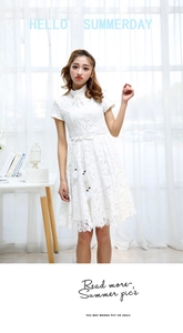 Close-up of a delicate white lace dress featuring a waist tie with tassels and leaf sequins
