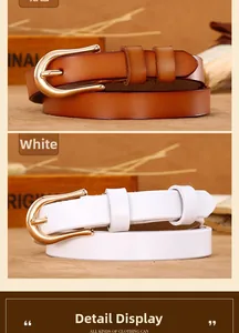 Detail of camel and white leather thin belts with golden horseshoe buckle on rustic wood