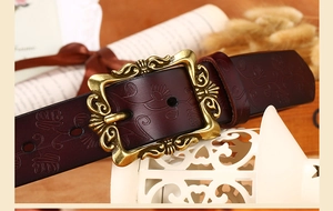 Gros plan sur une ceinture en cuir vintage avec boucle florale dorée antique ornée