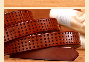 Close-up of a dark brown leather belt featuring intricate geometric cutout patterns