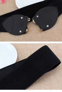 Detail showing the golden heart buckle backside and black elastic textured fabric of the belt