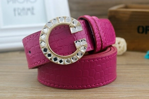 Close-up of pink faux leather belt with crocodile pattern and crystal G-shaped buckle