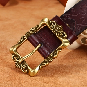 Ceinture vintage en cuir gaufré floral avec boucle dorée ornée sur fond brun