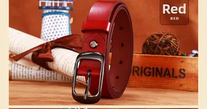 Dettaglio cintura in pelle rossa con fibbia in metallo scuro su sfondo scatola di legno vintage