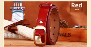 Dettaglio cintura in pelle rossa con fibbia ad ardiglione dorata e fori di regolazione