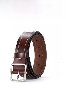 Detail of reddish-brown leather belt with white contrast stitching and silver square buckle