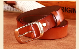 Detail of genuine brown leather belt with elegant gold metal pin buckle on vintage background