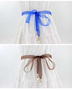 Détail de la ceinture en organza avec pendentif perle en bleu royal et marron café