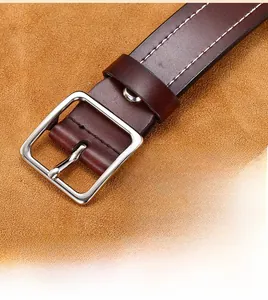 Macro shot of dark brown genuine leather belt with double white stitching and silver buckle