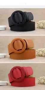 Detailed view of women's fashion belts in black, brown and red with round covered buckles