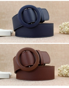 Detail of fashion women's belts featuring large leather-wrapped round buckles in navy and brown