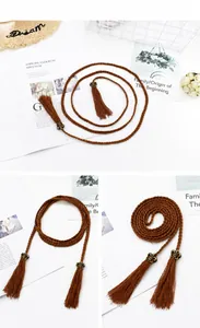 Dettaglio cintura boho intrecciata marrone con lunghe nappe e fibbia in bronzo antico