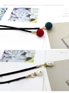 Detailansicht von gestrickten Kugeln und Perlenanhängern mit goldenen Beschlägen