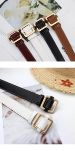 Detail of square gold metal buckles and fine contrast stitching on faux leather belts