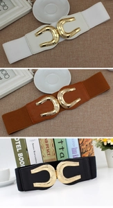 Close-up of gold horseshoe metal buckles on black, white, and brown elastic waist belts