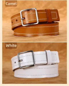 Detail of white and camel cowhide leather belts with silver buckles and stitch edges