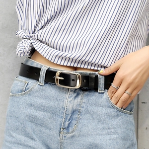 Classic black leather belt with polished metal buckle styled on blue denim jeans