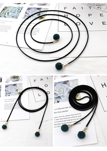 Detail der minimalistischen schwarzen Taillenkette mit grünen Kugeln und Goldbeschlägen