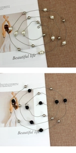 Detail of beaded metal waist chains in pearl white and black with lobster clasps
