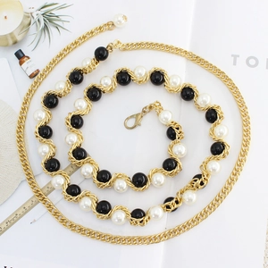 Ceinture élégante en chaîne dorée avec perles noires et blanches et fermoir mousqueton
