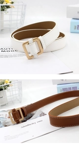 Detail of square gold buckle belts in white and brown leather with fine stitching