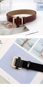 Detail of square gold buckles and double white stitching on black and wine red belts