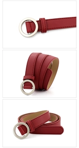 Détail d'une ceinture fine marron rougeâtre avec boucle ronde argentée et texture cuir