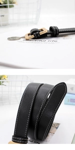 Detail view of black leather belt with white contrast stitching and gold square buckle clasp