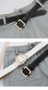 Detail of minimalist black and white leather belts with golden square buckle and stitching