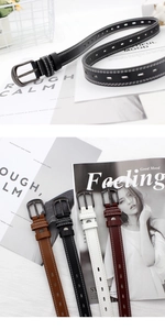 Detail of multi-color faux leather belts with vintage buckles and double stitching