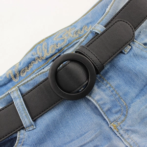 Minimalist black leather belt for women with a vintage round buckle on denim jeans