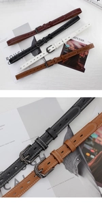 Close-up of four slim leather belts in red, black, white, and brown with contrast stitching