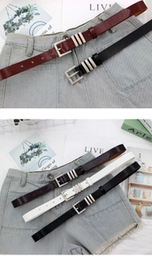 Detail of slim leather belts with silver needle buckles on light blue denim shorts