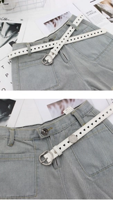 Détail de la ceinture blanche à découpes en cœur et boucle argentée sur un short