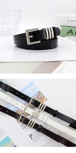 Close-up of three fashionable faux leather belts featuring silver metal pin buckles