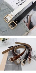 Close-up of minimalist women leather belts with golden square buckles on denim background