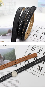 Close-up of minimalist women's slim belts in black and brown with silver pin buckle details