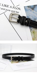 Detail of black leather belt featuring white contrast stitching and matte silver buckle