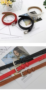 Close-up of slim leather belts with silver buckle and white stitching in four colors