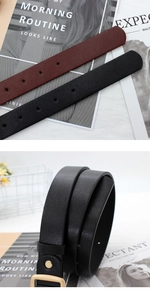 Detail view of black and wine red leather belts with textured finish and golden buckles