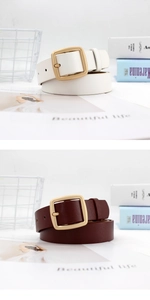 Close-up of pearl white and dark brown leather belts with matte gold square buckles