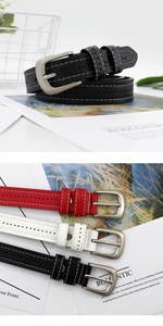 Detail of slim PU leather belts featuring white contrast stitching and silver pin buckle